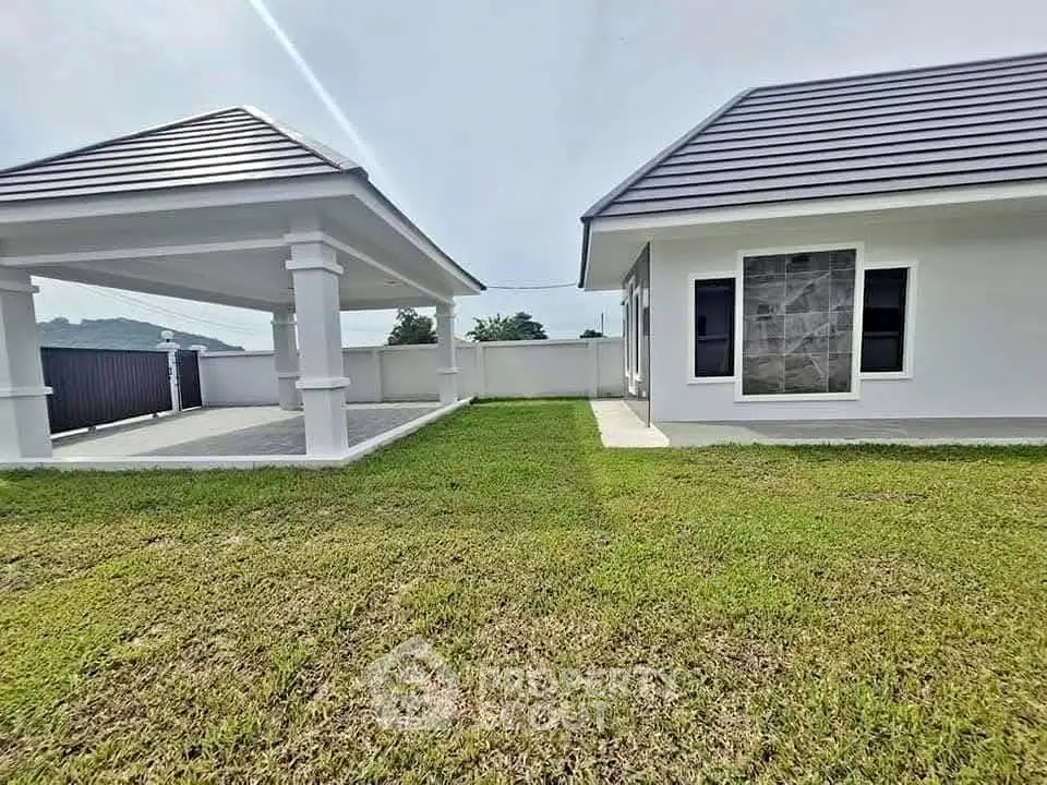 Modern single-story home with spacious lawn and covered patio area.