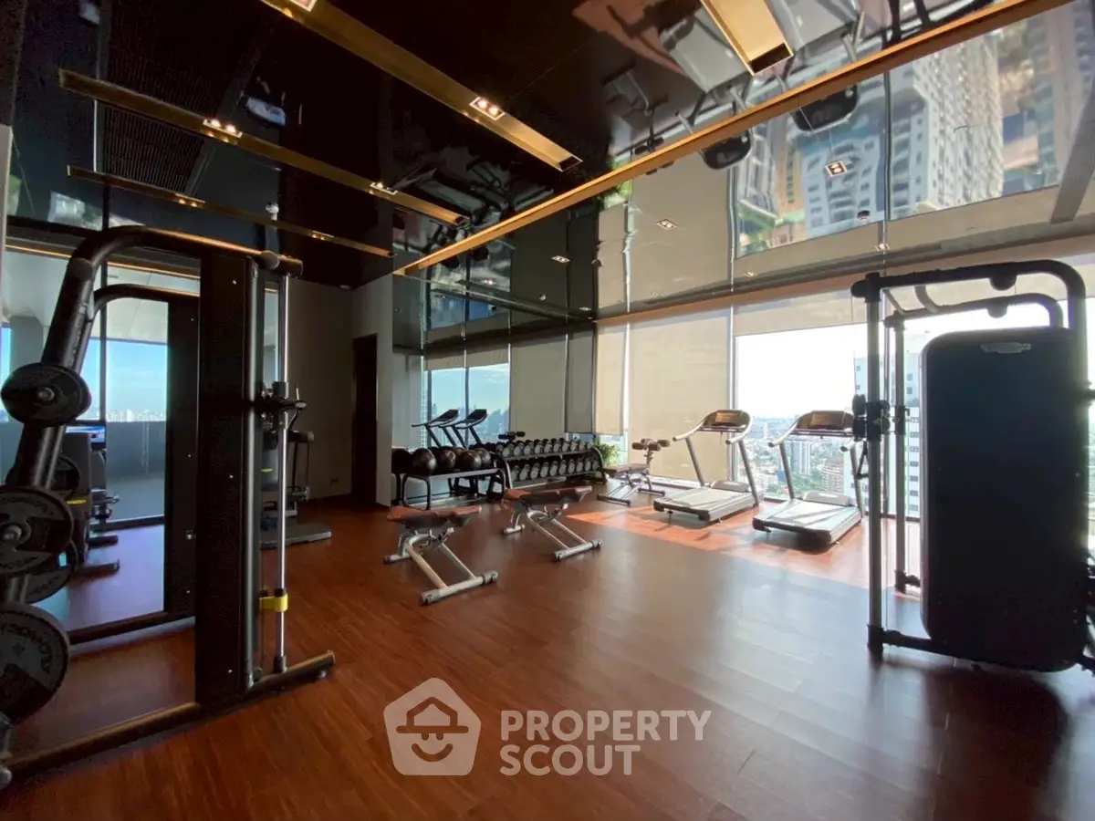 Luxurious high-rise gym with panoramic city views and modern fitness equipment.