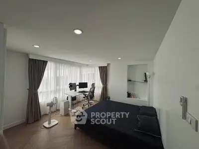 Modern bedroom with workspace, featuring a large window and minimalist decor.