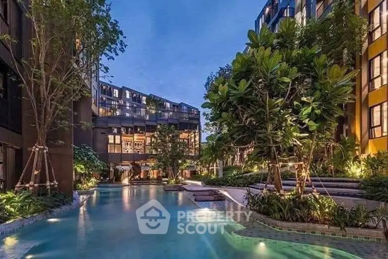 Luxurious residential complex with stunning pool and lush greenery at dusk.