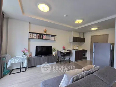 Modern living room with open kitchen, stylish decor, and cozy seating area in a contemporary apartment.