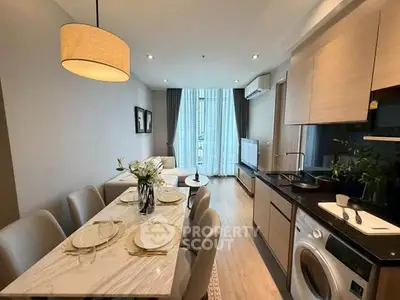 Modern open-plan living room and kitchen with elegant dining area and natural light.