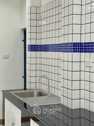 Modern kitchen with sleek black countertop and stylish tiled backsplash