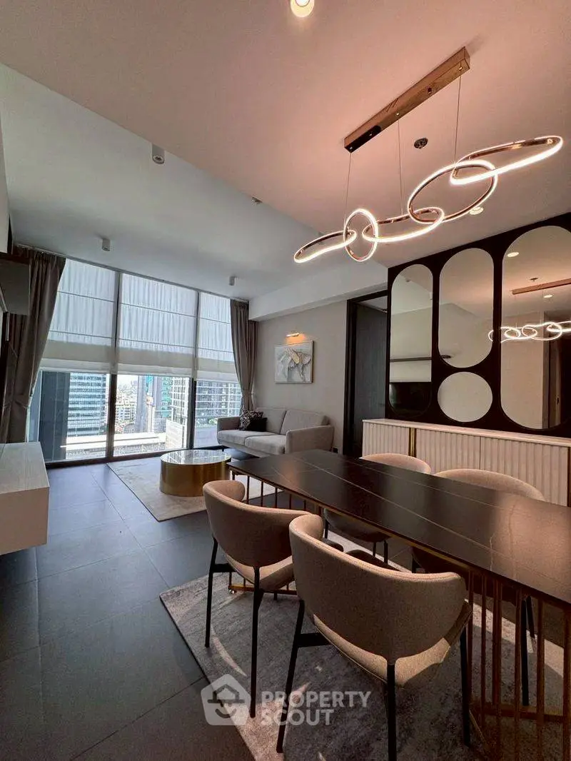 Modern living room with elegant dining area and city view, featuring stylish lighting and contemporary decor.