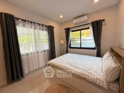 Cozy bedroom with large windows and modern decor, perfect for relaxation.