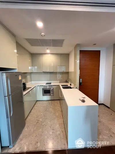 Modern kitchen with sleek cabinetry and stainless steel appliances in a contemporary apartment.