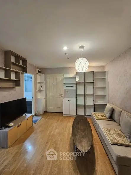 Cozy living room with modern decor and wooden flooring in a stylish apartment.