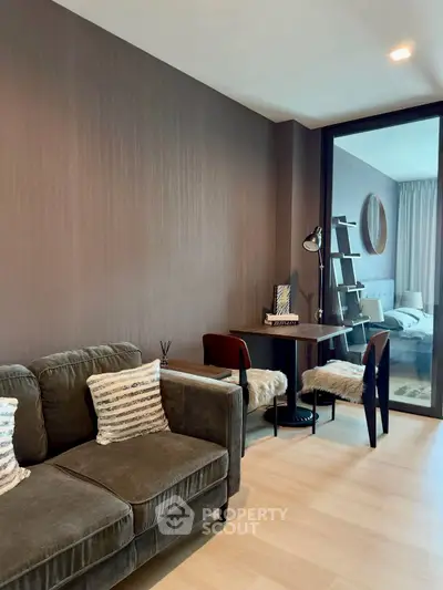 Modern living room with cozy seating and stylish decor adjacent to a bedroom.