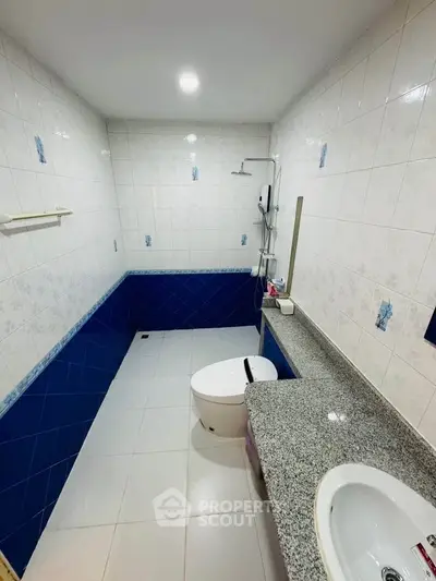 Spacious bathroom with modern fixtures and blue tile accents
