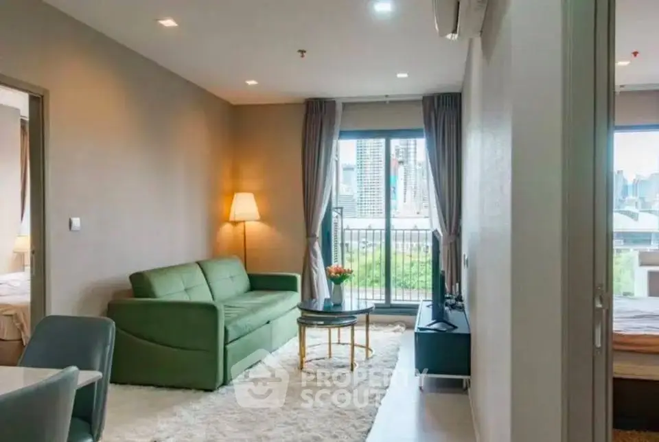 Modern living room with city view, featuring a green sofa and cozy decor.