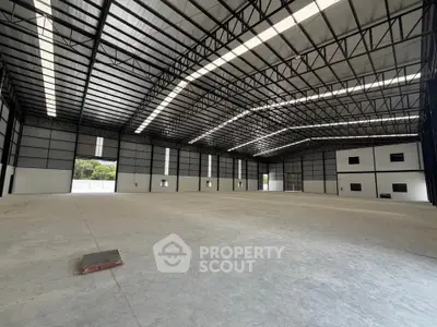 Spacious industrial warehouse with high ceilings and ample natural light.