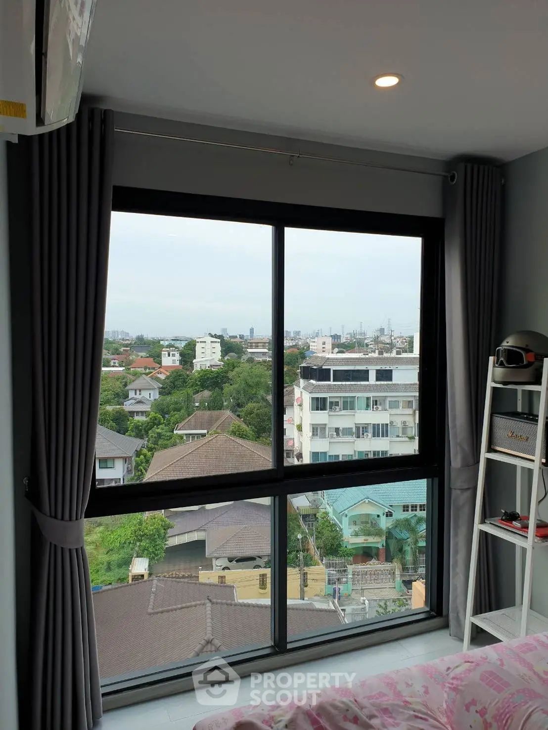 Modern bedroom with large window offering stunning city view