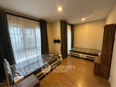 Spacious bedroom with twin beds and large windows for natural light