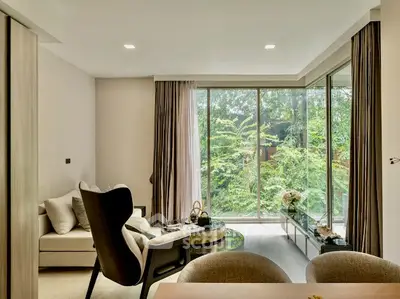 Modern living room with large windows and lush garden view, featuring stylish furniture and elegant decor.