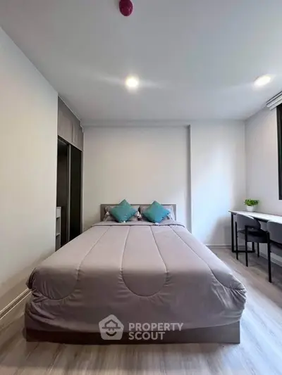 Modern bedroom with cozy bed and study area, perfect for relaxation and productivity.