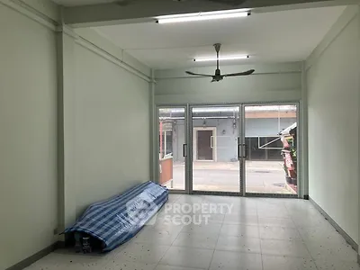 Spacious empty room with large windows and ceiling fan, ideal for customization.