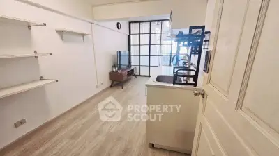 Spacious living room with modern decor and open layout, featuring a sleek TV stand and stylish shelving.