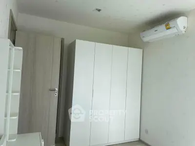 Minimalist bedroom with white wardrobe and air conditioning unit