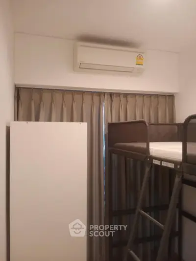 Compact bedroom with bunk bed and air conditioning unit