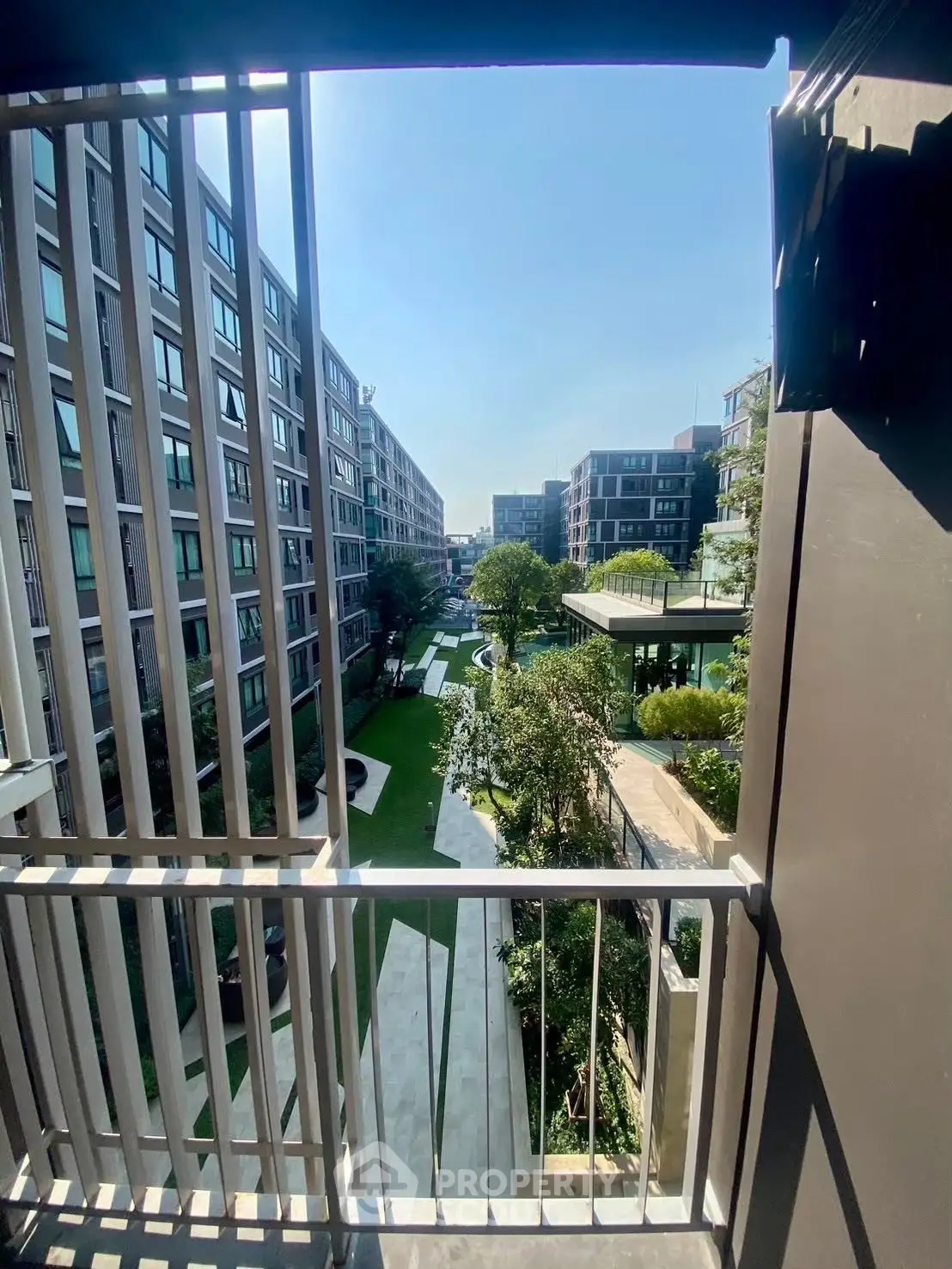 Modern apartment complex with lush garden view from balcony
