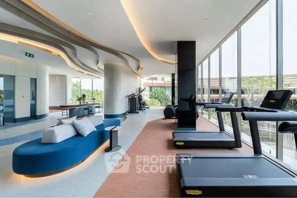 Luxurious gym with modern equipment and panoramic windows in upscale building.