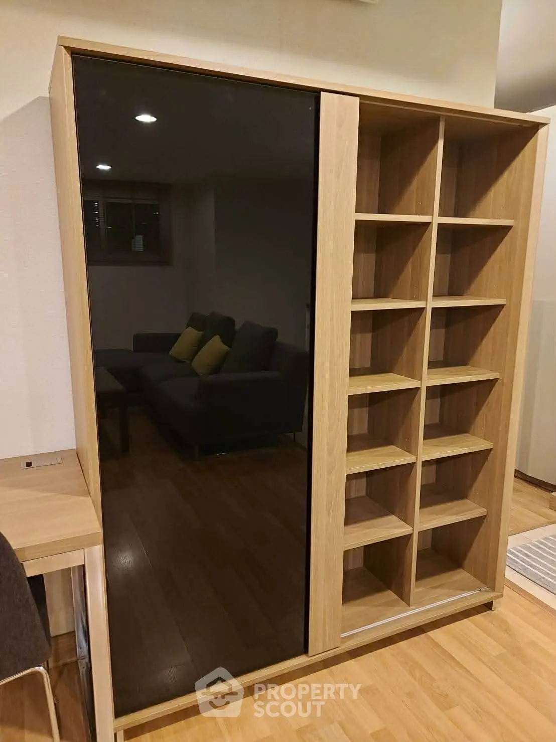 Modern living room with stylish wooden shelving and sleek black glass panel