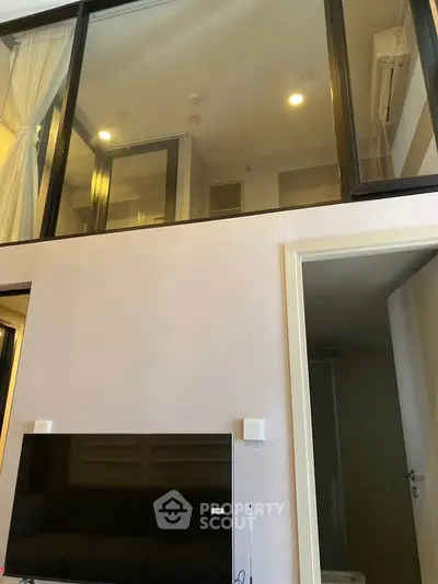 Modern duplex apartment with high ceilings and large windows, featuring a stylish mezzanine level.