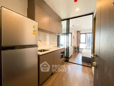 Modern studio apartment with sleek kitchen and cozy living area, perfect for urban living.