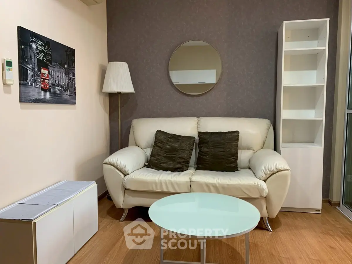 Cozy living room with modern decor, featuring a white sofa, round mirror, and stylish shelving unit.
