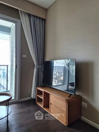 Modern living room with sleek TV and balcony view, perfect for urban living.