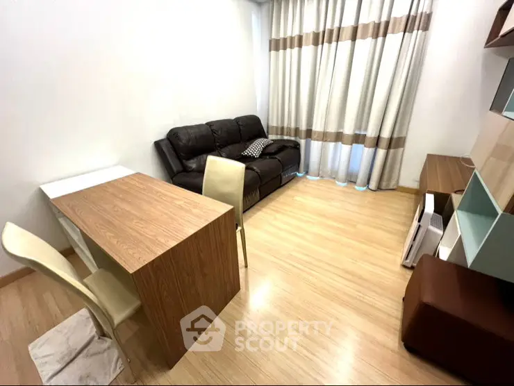 Modern living room with wooden flooring, cozy sofa, and dining table in a stylish apartment.