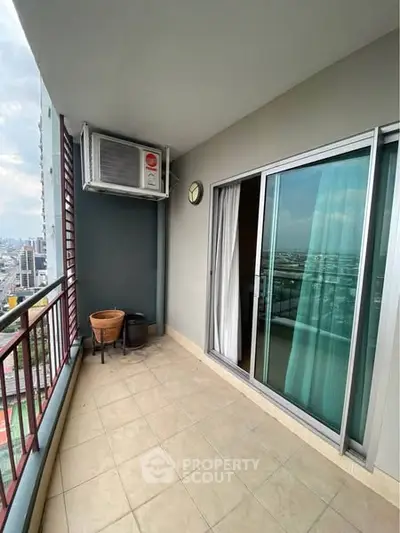 Spacious balcony with city view and sliding glass doors in modern apartment.