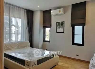 Modern bedroom with large windows and air conditioning in a stylish apartment.