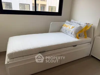 Modern minimalist bedroom with single bed and large window view.