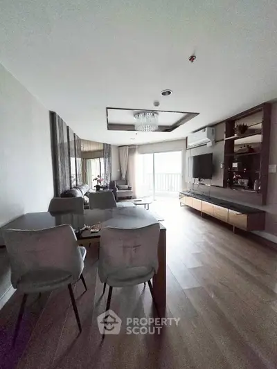Spacious modern living room with elegant decor and balcony access, perfect for relaxation and entertainment.