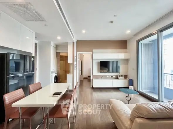 Modern living room with open layout, stylish furniture, and large windows for natural light.