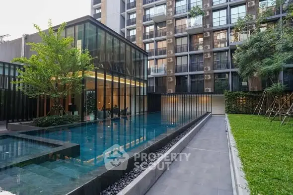 Modern apartment complex with sleek pool and lush greenery