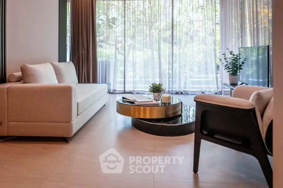 Elegant living room with modern furniture and large windows offering a serene garden view.
