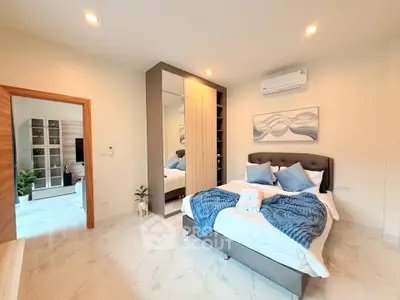 Luxurious bedroom with modern decor and ample natural light, featuring a stylish bed and elegant furnishings.