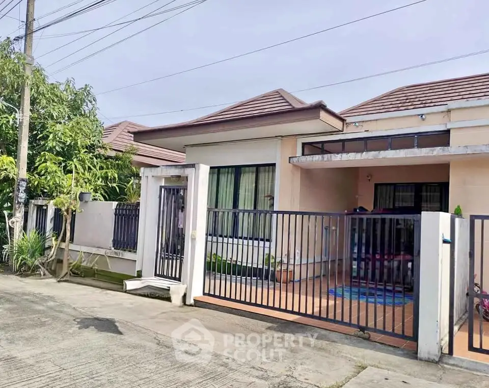 Charming single-story house with gated entrance and cozy front patio in a serene neighborhood.