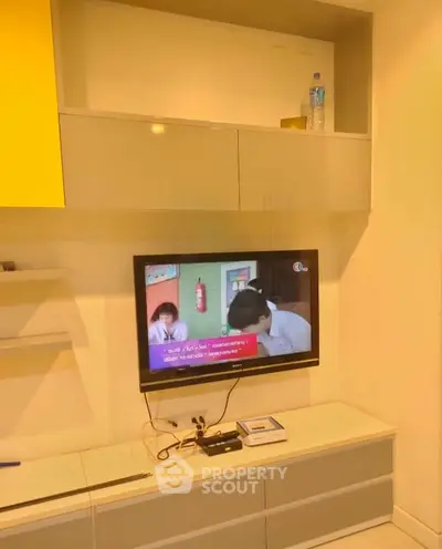 Modern living room with wall-mounted TV and sleek storage cabinets.