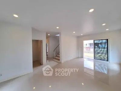 Spacious modern living room with sleek staircase and large windows
