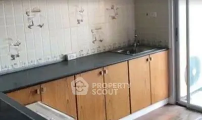 Charming kitchen with wooden cabinets and sliding glass door access.