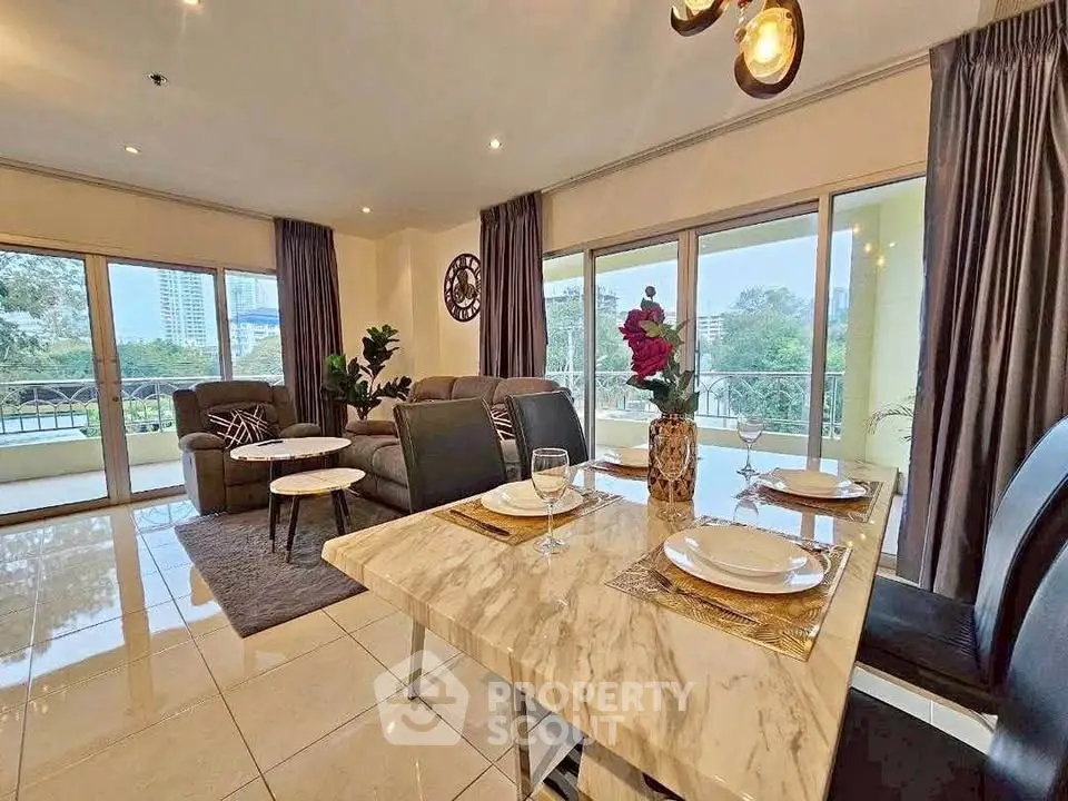 Spacious living room with elegant dining area and large windows offering scenic views.