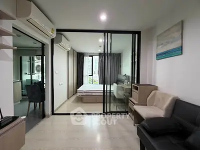 Modern apartment interior with glass partition, cozy living area, and stylish bedroom.