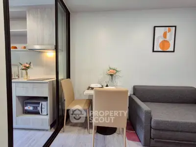 Modern compact living space with kitchen and dining area, featuring stylish decor and cozy seating.