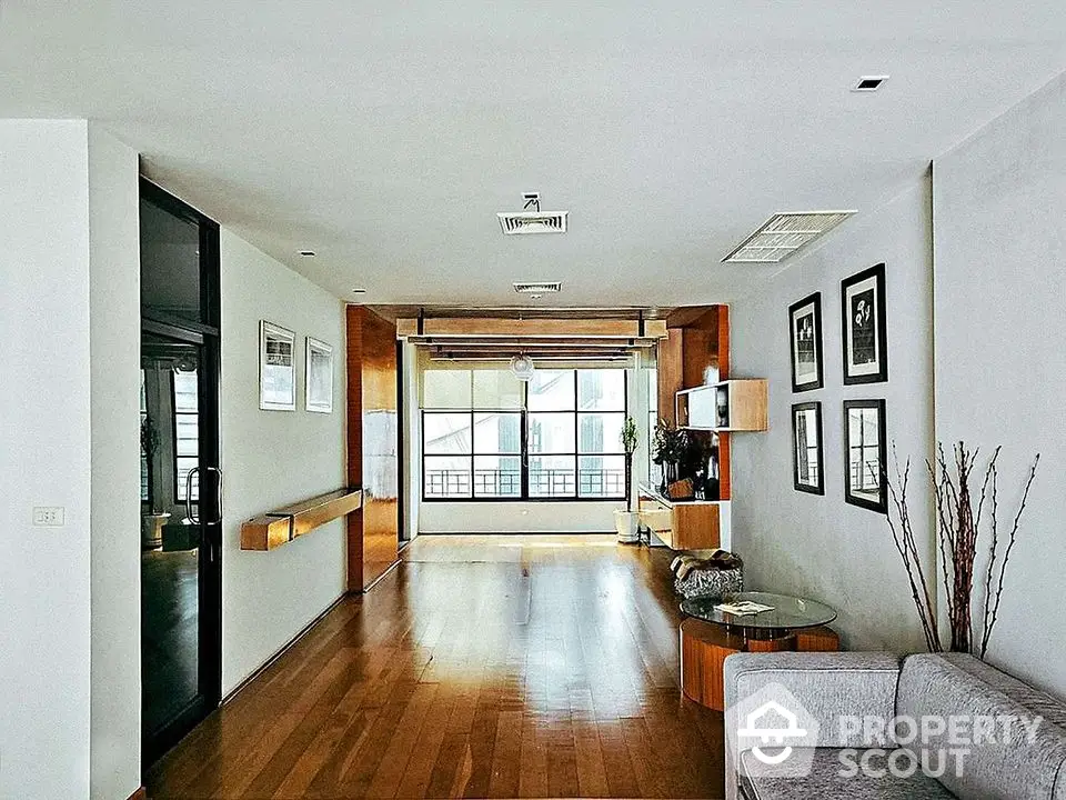 Spacious modern living room with wooden flooring and large windows