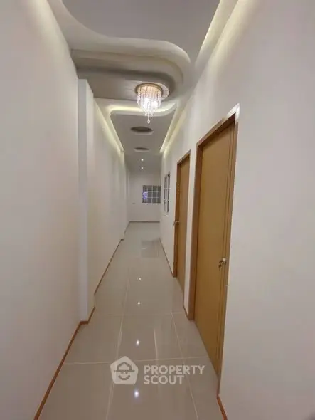 Elegant hallway with modern lighting and sleek tile flooring in a contemporary building.