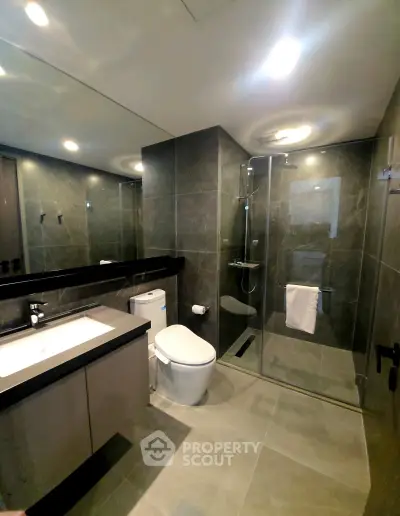 Modern bathroom with sleek design, glass shower, and elegant fixtures in luxury real estate property.