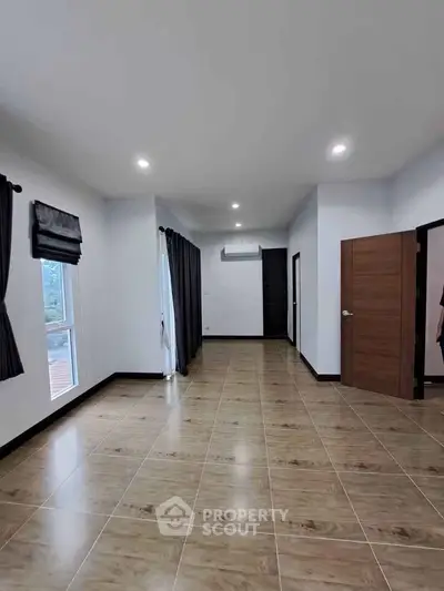 Spacious modern living room with wooden flooring and ample natural light